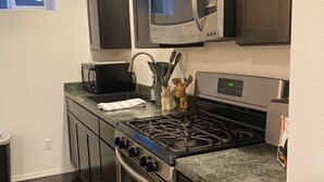 A kitchen with dark cabinets, a stainless steel stove, a microwave, and a sink. - Downtown!  Great neighborhood!  Walk everywhere downtown!   (Anchorage)