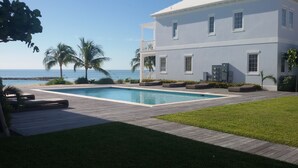 A large house with a swimming pool, a wooden deck, and a view of the ocean. - DESIGN STUNNING LUXURY BEACH-HOUSE FULLY RENOVATED 5 Stars L (Nassau)