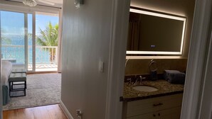 A modern bathroom with a large mirror, a sink, and a shower area. - DESIGN STUNNING LUXURY BEACH-HOUSE FULLY RENOVATED 5 Stars L (Nassau)