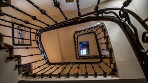 Eine Wendeltreppe mit aufwendiger Metallgeländerung und einem kleinen Fenster oben.