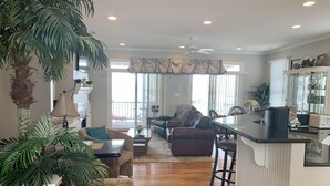 A spacious living area with a sofa, a coffee table, and a dining area with a bar. - Beautiful Retreat with Ocean & Sound Views (Atlantic Beach)