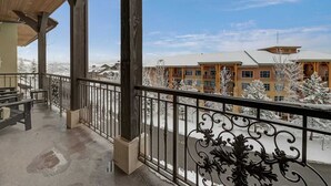 Un balcon fermé offrant une vue sur un bâtiment enneigé.