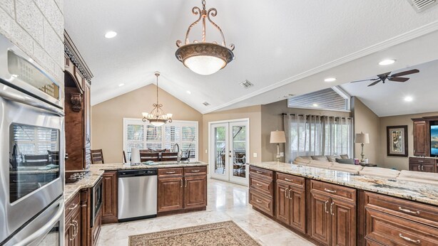 A spacious kitchen with a large island, stainless steel appliances, and wooden cabinetry.