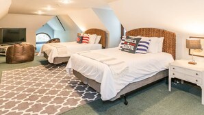 Une chambre avec deux lits, une télévision et une grande fenêtre.