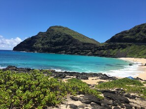 A beach with clear turquoise water, rocky shoreline, and lush green hills in the background. - Wonderful retreat, Fantastic View, Immaculate, Beautiful, Private and Peaceful! (Honolulu)