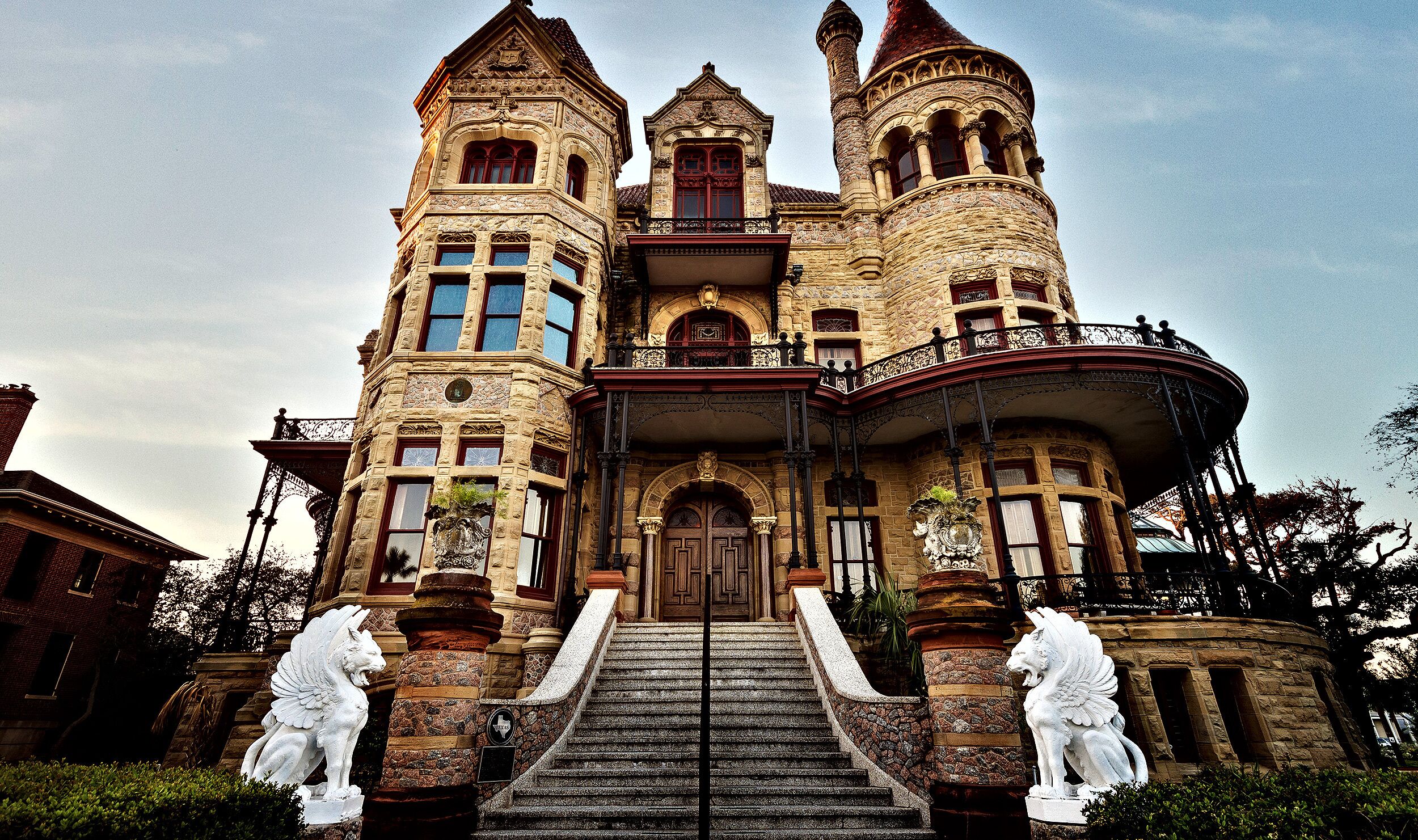 Un edificio histórico y majestuoso, con una entrada central, dos torres y un balcón.