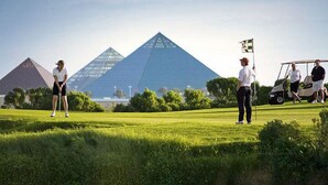 Un campo da golf con le piramidi sullo sfondo.