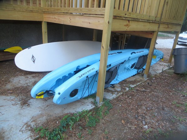 A kayak and a surfboard under a wooden deck. - Riverfront House With Dock Sleeps 8 (St Simons Island)