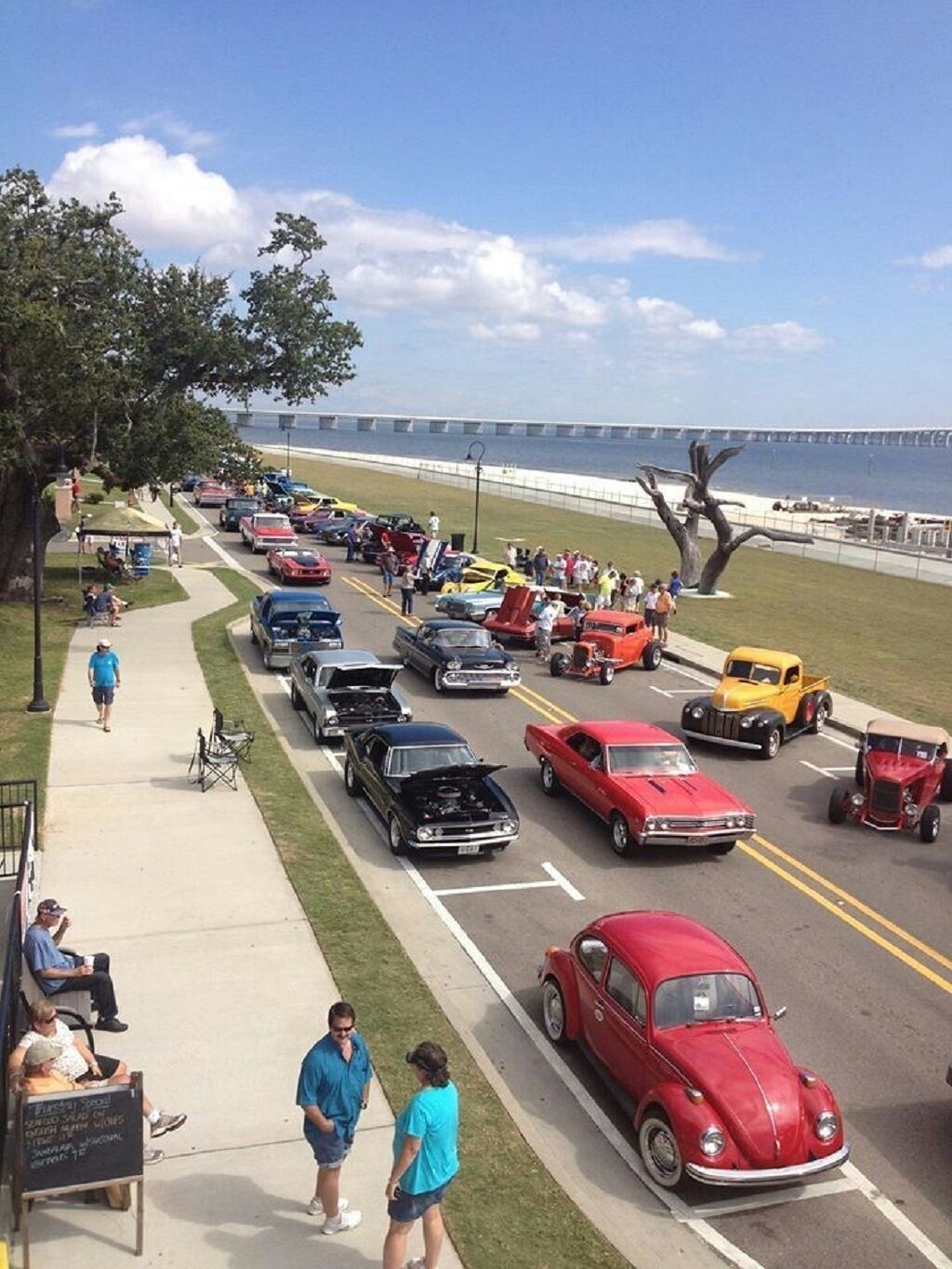 Un estacionamiento con autos clásicos y vista al mar.