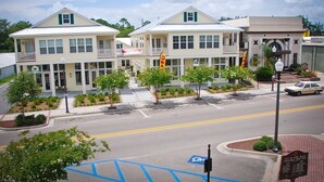 A two-story building with a flat roof, large windows, and a balcony on the second floor.