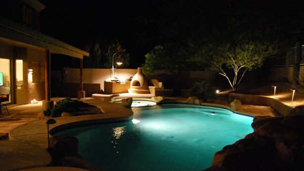 Une piscine bordée de pierres, un jacuzzi et un espace salon couvert pour les soirées.