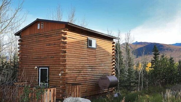 A log cabin with a simple design, a small window, and a door.