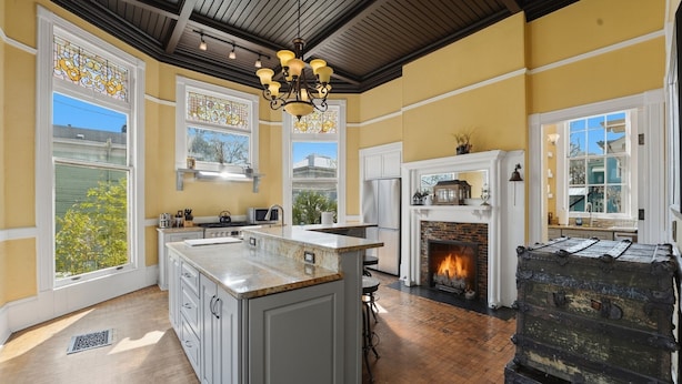 A kitchen with a large island, a fireplace, and a view of the outdoors.