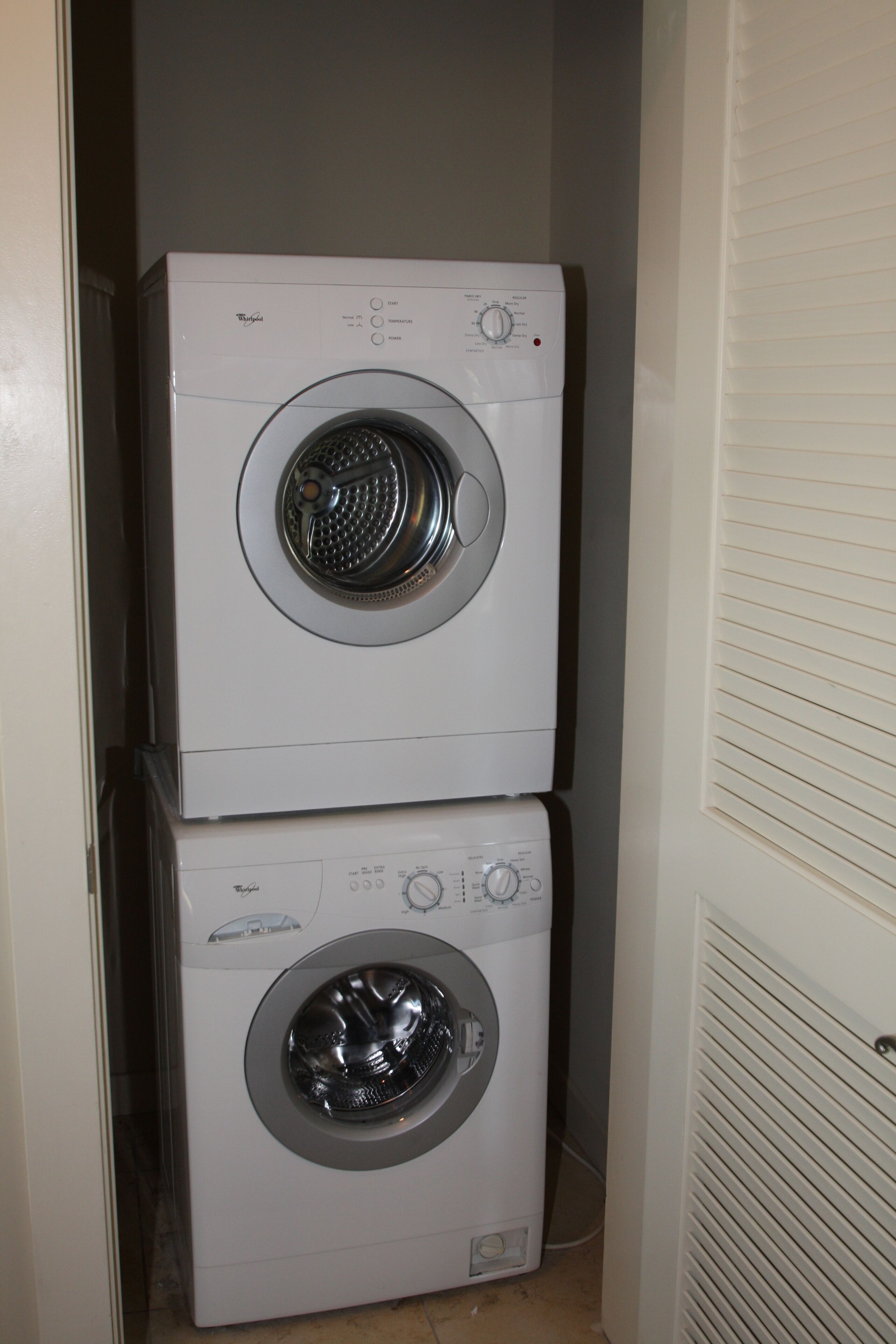 A stacked washer and dryer unit in a laundry room.