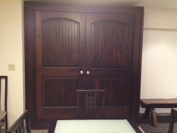A closed wooden door with a small window and a metal handle.