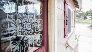 Un bâtiment avec une porte rouge et des vitraux décoratifs ornés de motifs floraux.