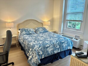 A bedroom with a bed, two bedside lamps, a chair, a desk, a window with blinds, and an air conditioning unit. - TROPICAL PALM BEACH SUITE- 3 BEDS 2BEDROOMS 2BATHS POOL,BEACH,FRONT DESK 24/7 (PALM BEACH)