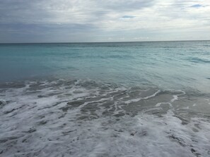 A beach with clear turquoise water and white foam on the shore. - TROPICAL PALM BEACH SUITE- 3 BEDS 2BEDROOMS 2BATHS POOL,BEACH,FRONT DESK 24/7 (PALM BEACH)