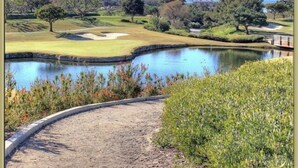 Ein Golfplatz mit Teich, Brücke und blauem Himmel.