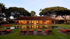 A hotel with a pool, outdoor seating, and a well-lit facade. - Aina Nalu Studio, Great Rates & Location, AC & WIFI,  2 Pools & Jacuzzi (Lahaina)