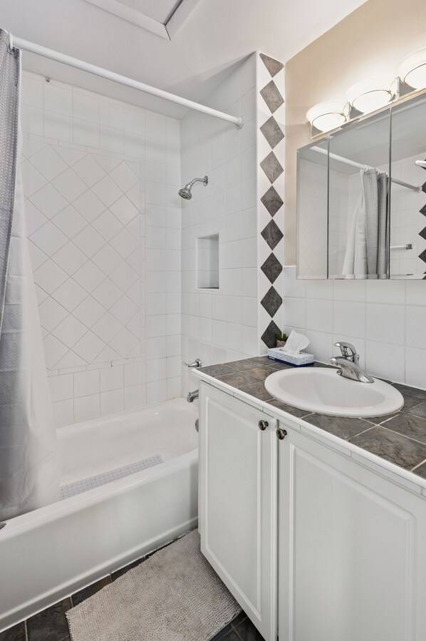 Un baño moderno con bañera, lavamanos y ducha.