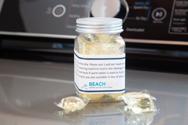 A jar of liquid soap with a label, placed on a reflective surface.