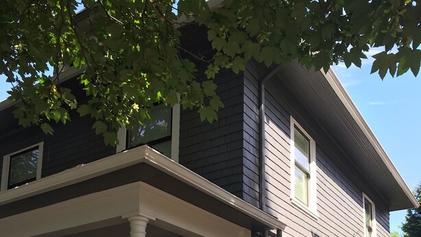 A two-story house with a covered porch and a garden. - Pet friendly apartment with covered patio and fenced-in yard. (Portland)