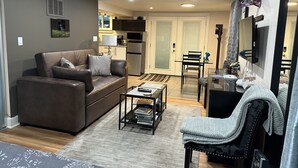 A living room with a sofa, coffee table, and a dining area with chairs and a table. - Pet friendly apartment with covered patio and fenced-in yard. (Portland)