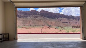 A room with a large window offering a view of a mountainous landscape.