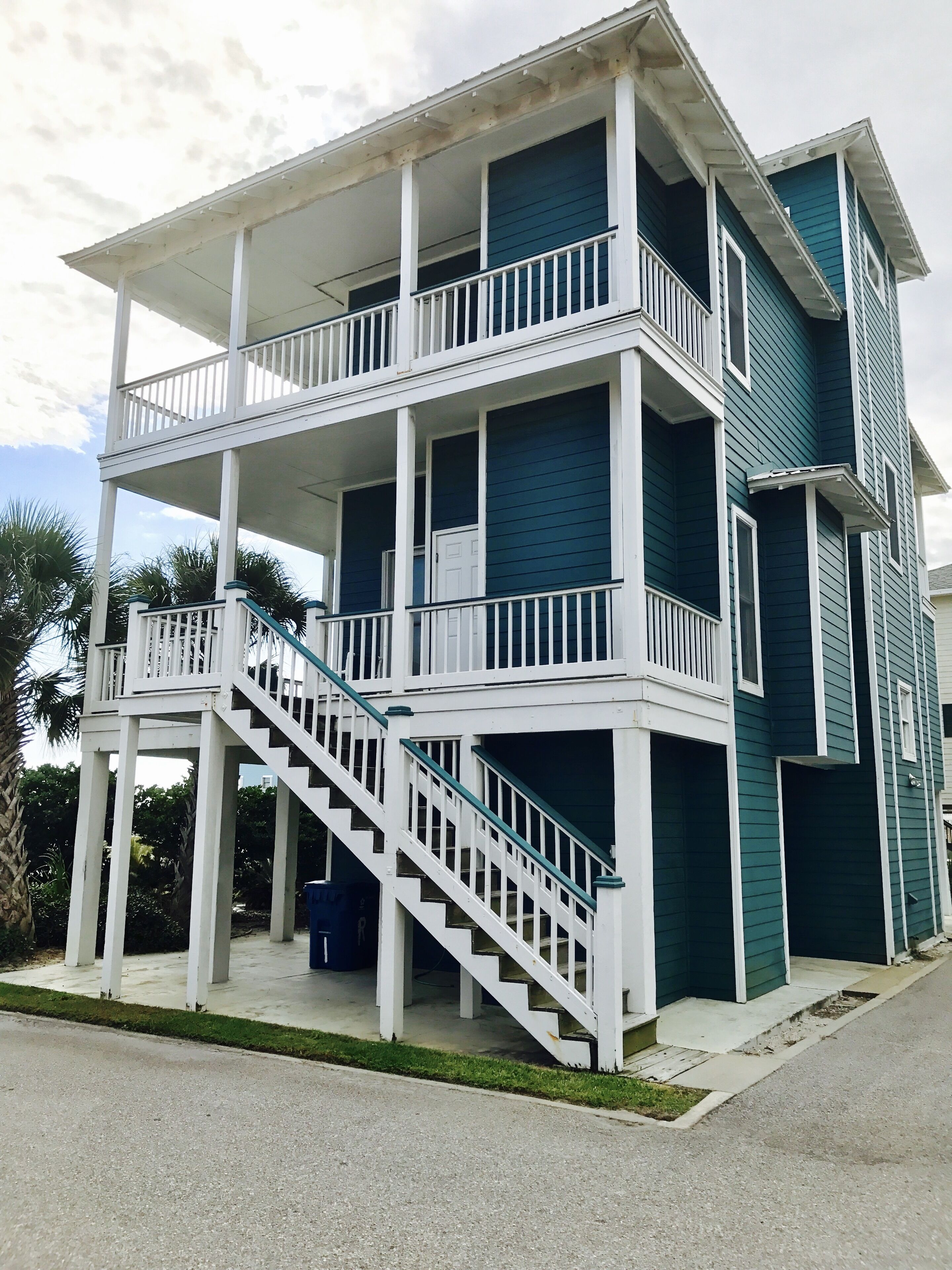 A multi-story building with a balcony and a staircase leading to the upper floor.