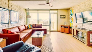 A modern living room with a leather sofa, a coffee table, and a flat-screen TV.