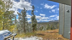 A view from a window overlooking a snowy landscape with trees and mountains in the distance. - Remodeled Condo Near Slopes, Pool/Hot Tub Access! (Silverthorne)