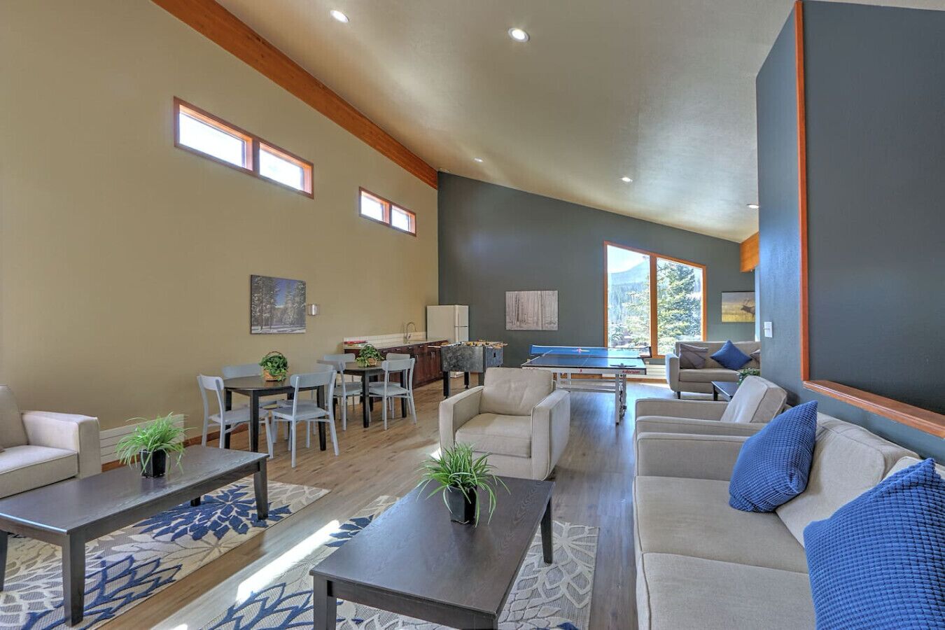 A spacious living area with a dining table, sofas, and a ping pong table.