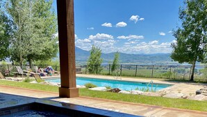 A hot tub with a view of a swimming pool and mountains in the background. - Big Piney Family Fun (Eden)