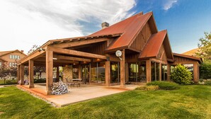 A modern house with a covered patio, large windows, and a well-maintained lawn. - Big Piney Family Fun (Eden)