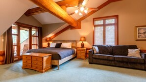 A bedroom with a wooden ceiling, a bed, a nightstand, a dresser, a sofa, and a window with blinds. - Ski In/Out to your Hot Tub. Pool Table (Fernie)