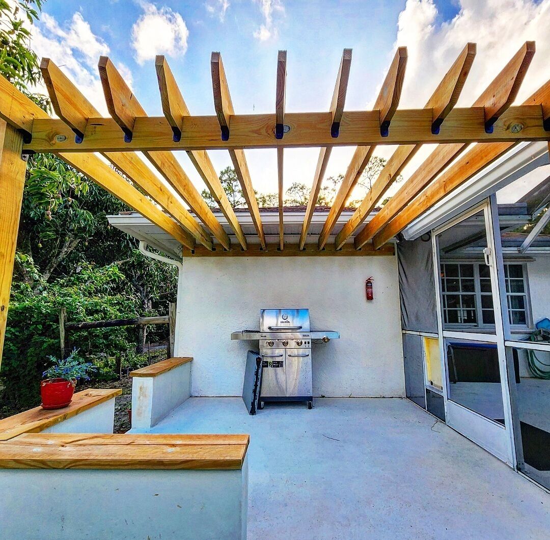 A covered patio area with a built-in grill and seating.