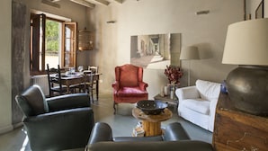 A spacious living room with a dining area, a red armchair, a white sofa, and a large table with a bowl. - PEACEFUL OASIS IN THE HEART OF FLORENCE (FLORENCE)