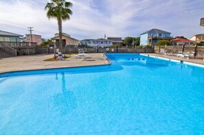 A swimming pool with a clear blue water, surrounded by a fence, and houses in the background. - Dolphin Cove-Boat dock, beach access, pool/hot tub- Off-Season Monthly Rental! (Surf City)