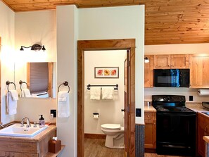 A bathroom with a sink, mirror, towel rack, and toilet.