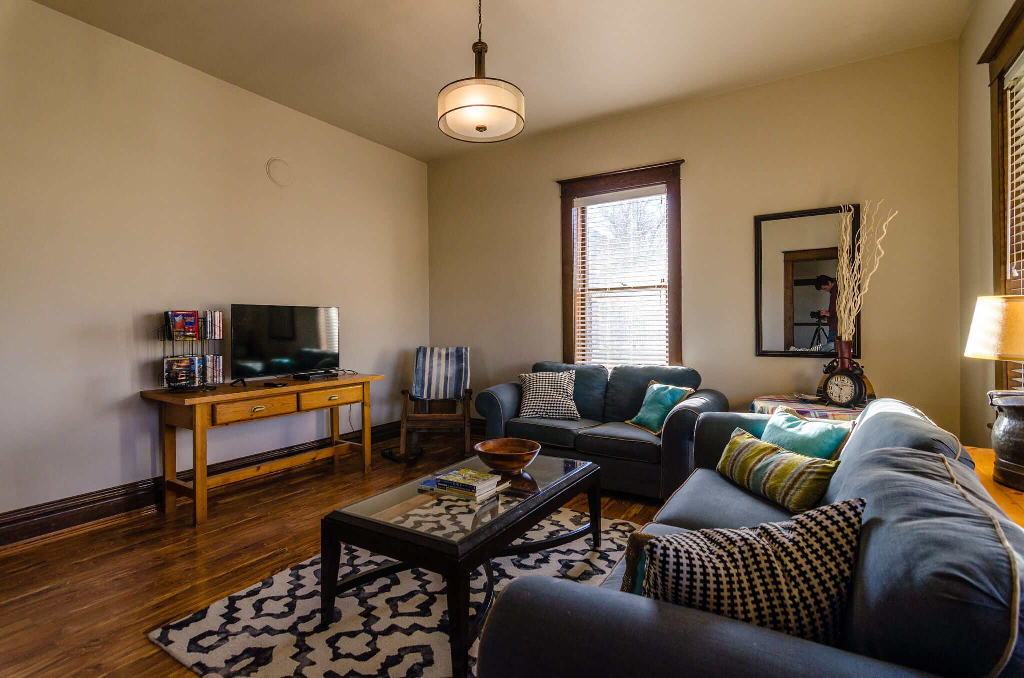 A living room with a sofa, coffee table, and a television on a wooden stand.