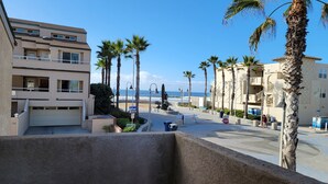 Un quartier résidentiel situé sur la côte, avec des immeubles à plusieurs étages, des palmiers et une vue sur l’océan.