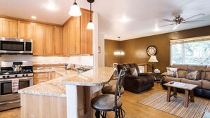 Une cuisine moderne avec des meubles en bois, des appareils électroménagers en acier inoxydable et un îlot central.