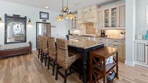 A kitchen with a central island, bar stools, and a dining table. - The  Kure . (Kure Beach)