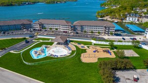 A hotel with a swimming pool, playground, and a view of the lake. - Breathtaking View - Top Floor Lands End Condo, POOL & lazy river! BEST location! (Osage Beach)