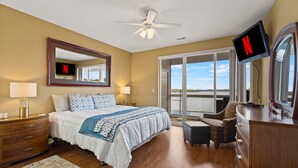 A hotel room with a bed, a TV, a dresser, a chair, and a balcony with a view. - Breathtaking View - Top Floor Lands End Condo, POOL & lazy river! BEST location! (Osage Beach)