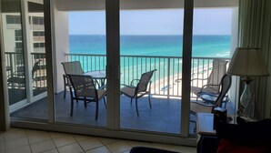 A balcony with a view of the ocean, furnished with chairs and a table. - Amazing Beachfront Destin Condo With Ocean Views from All Rooms (Destin)