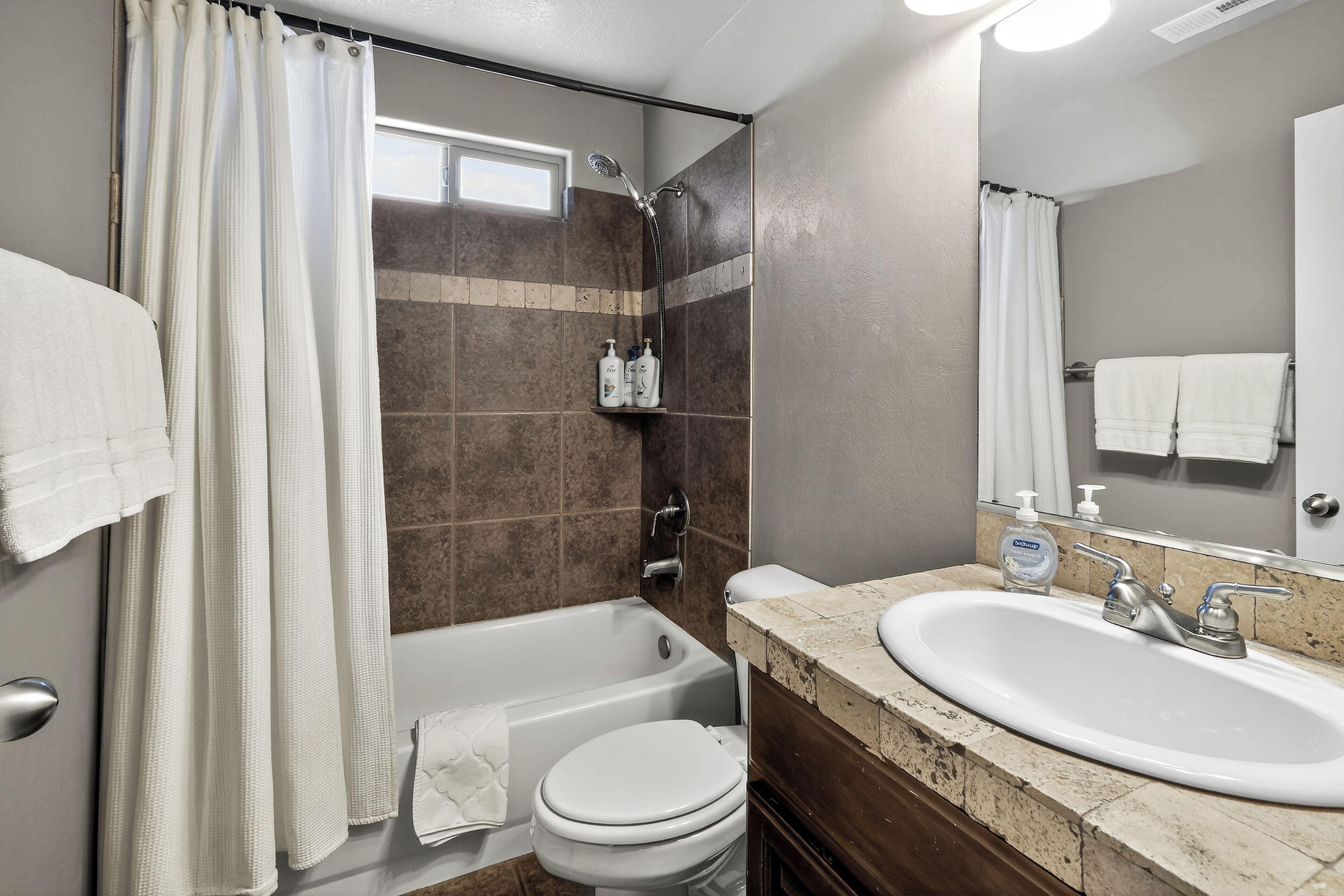 A bathroom with a bathtub, toilet, sink, and shower.