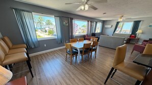 A spacious living area with a dining table, chairs, and a sofa.