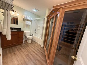 Et badeværelse med toilet, håndvask og bruser.